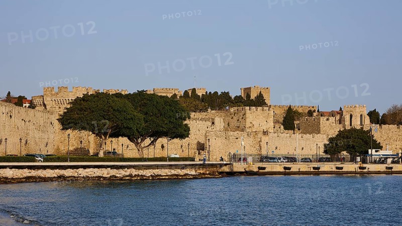The fortress walls on the coast form a peaceful retreat next to the clear water, Outer city walls, harbour area, Rhodes Town, Rhodes, Dodecanese, Greek Islands, Greece, Europe