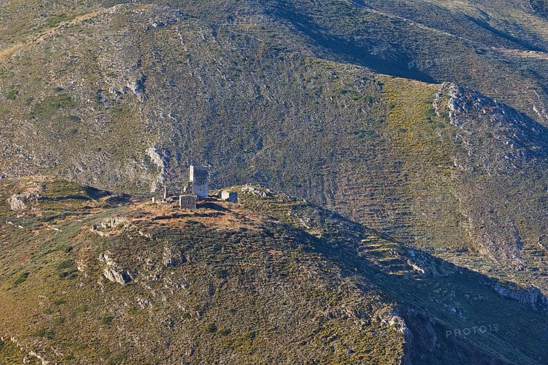 An old ruined tower on a hilly mountain with green vegetation on a sunny day, Mani Peninsula, Peloponnese, Greece, Europe