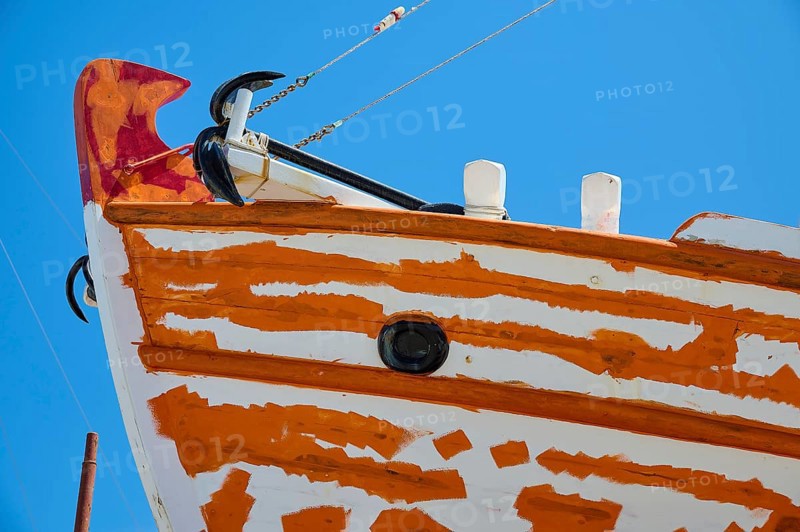 Close-up of the bow of a sailboat with orange and white paint and anchor in front of a blue sky, Patmos Marine, boatyard, Diakofti, Patmos, Dodecanese, Greek Islands, Greece, Europe