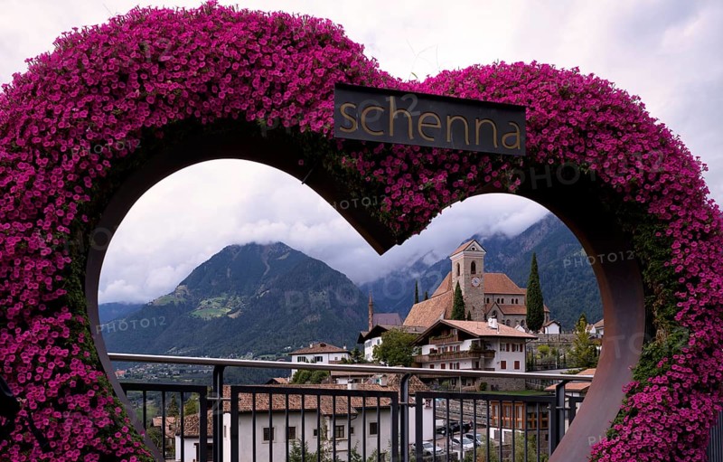 Photopoint, sign, flower heart, heart made of flowers, behind it the new parish church Maria Himmelfahrt, Schenna, Scena, South Tyrol, Autonomous Province of Bolzano, Italy, Europe