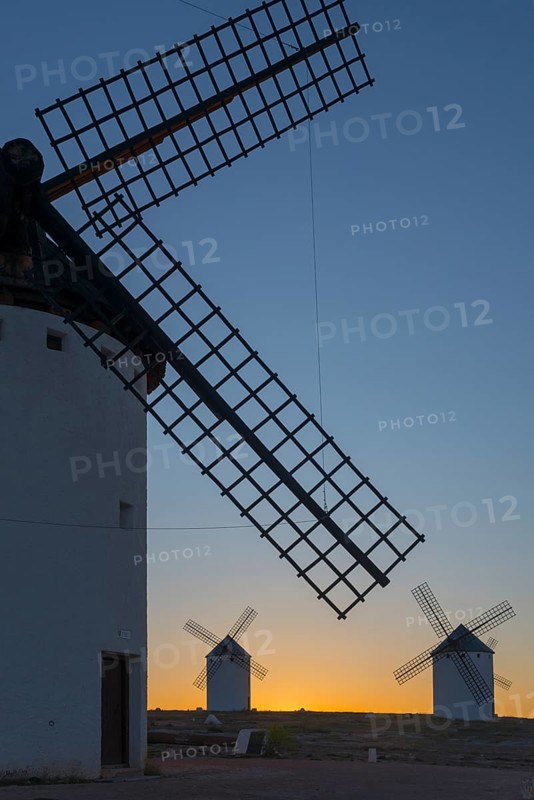 Close-up of a windmill in the foreground with two others on the horizon at sunset, windmills, Campo de Criptana, Ciudad Real province, Castilla-La Mancha, Route of Don Quixote, Spain, Europe