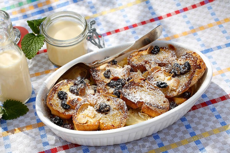 Swabian cuisine, Ofenschlupfer, sweet main course or dessert, dessert, sweet dish, typical Swabian, classic, from the oven, casserole, leftovers, rolls with sultanas, apples, gratinated, vanilla sauce, icing sugar, prepared, home cooking, traditional cuisine, food photography, studio, Germany, Europe