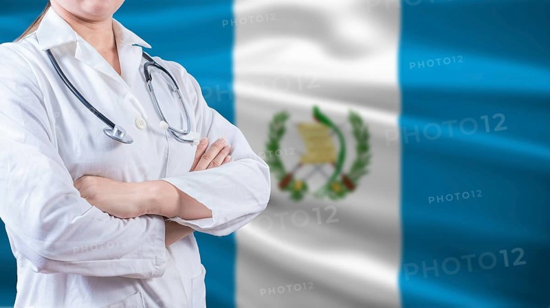 Healthcare concept with Guatemalan flag in background. Doctor with arms crossed with Guatemala flag background