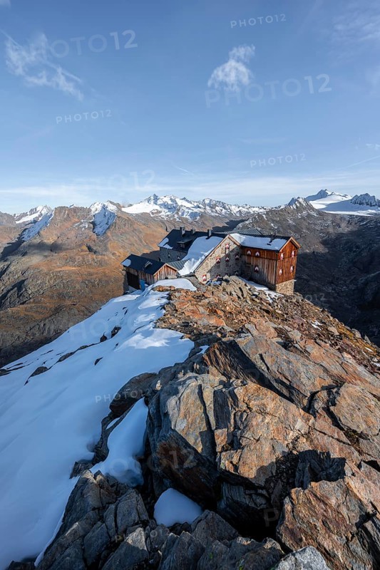 Snowy mountain landscape, mountain hut Ramolhaus in autumn with snow, in the evening light, view of Gurgler Ferner with summit Hochwilde and Falschungsspitze, Ötztal Alps, Tyrol, Austria, Europe