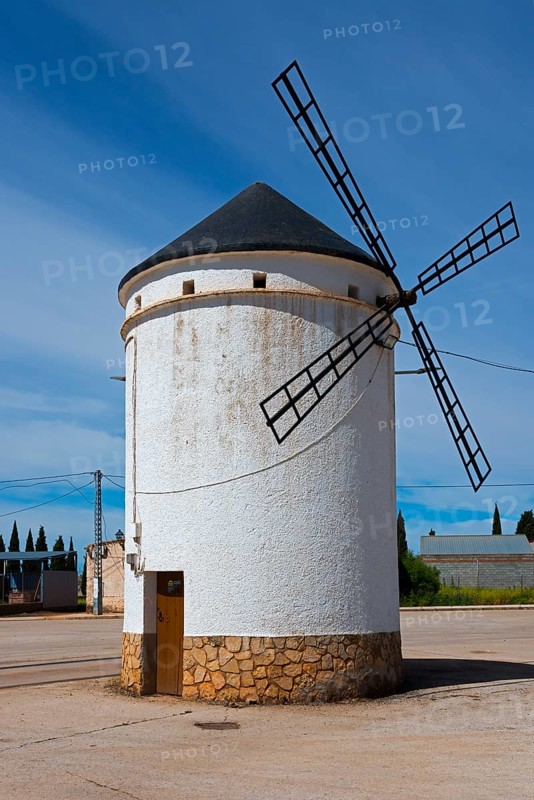 Small white windmill with blades and stone base under a clear sky, Mill, Molino de Villahermosa, La Mancha, Ciudad Real, Castilla-La Mancha, Spain, Europe