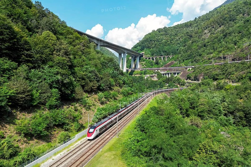 Railway passenger train of the type Stadler Flirt of the Südostbahn on the Gotthard railway Aerial view in the Alps in Giornico, Switzerland, Europe