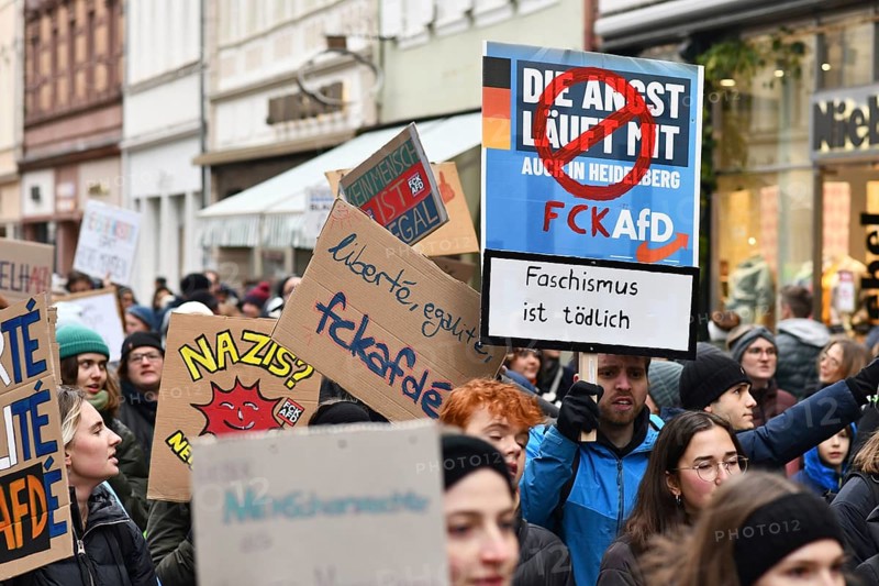 Heidelberg, Germany - February 12th 2025: Young people holding up signs in crowd at protest against far-right