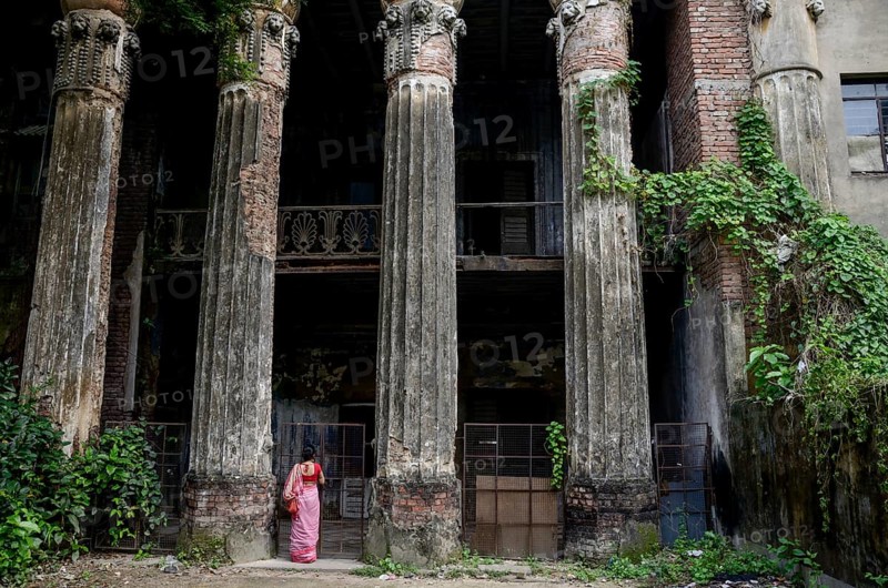 Woman standing below old palace, Kolkata, West Bengal, India, Asia