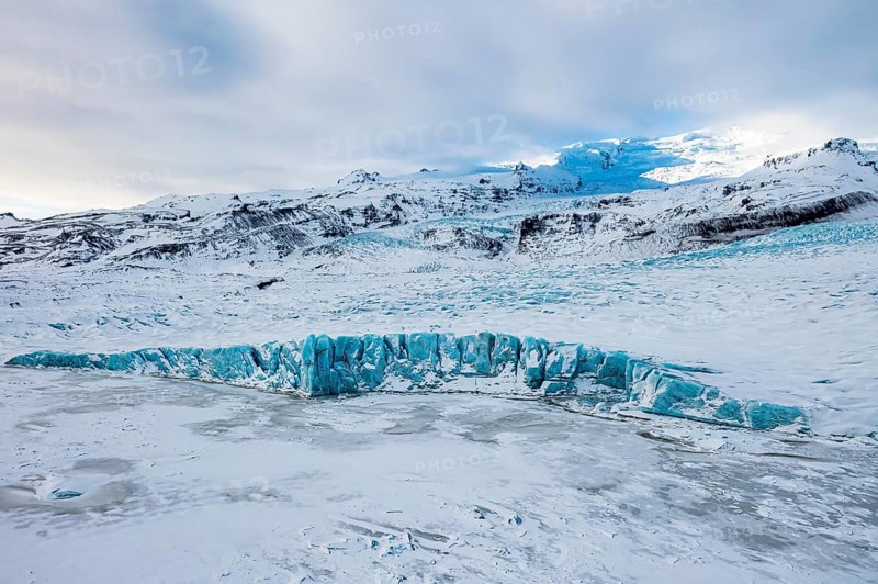 Snow-covered icebergs in the Fjallsarlon glacier lagoon, with the Öraefajökull glacier behind, drone shot, Sudurland, Iceland, Europe