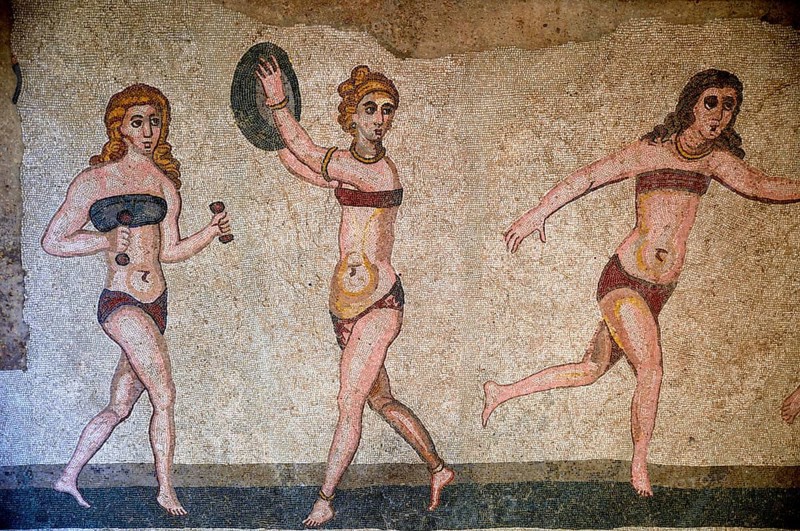 Floor mosaic of three women in bikini during sports, Bikini Girls' Hall, Villa Romana del Casale, 4th century AD Roman villa, Piazza Armerina, Enna Province, Sicily, Italy, Europe