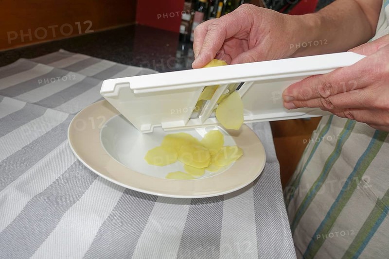 Preparation of cress soup with crisps, cutting potatoes, slicing, vegetable slicer, grating, Swabian cuisine, hearty soup, vegetarian, healthy, salty, typical Swabian reinterpreted, traditional cuisine, food photography, studio, men's hands, tea towel, Germany, Europe