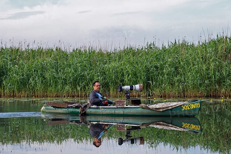 Nature park photographer in a kayak on the river Trebel at work, Naturpark Flusslandschaft Peenetal, Mecklenburg-Western Pomerania, Germany, Europe