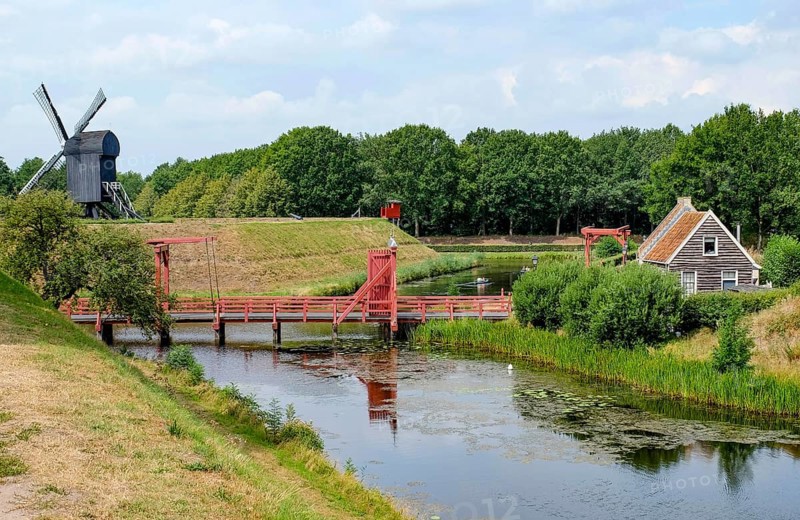 Bourtange Fortress, drawbridge over fortress moat, trestle windmill, Groningen Province, Netherlands