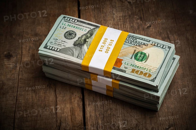 Creative business finance making money concept, stacks of new 100 US dollars 2013 edition banknotes bills bundles on wooden background