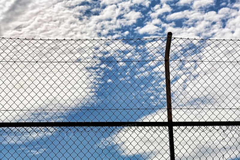 View through wire mesh fence, wire mesh on fence, cloudy sky, symbol image obstacle, exclusion, imprisonment, background image