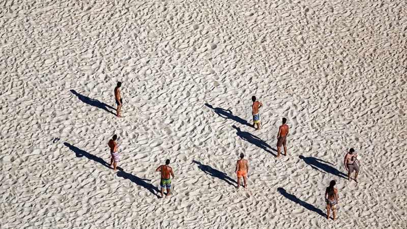 Beach volleyball on the beach of Nazaré, players cast long shadows, view from above, Portugal, Europe