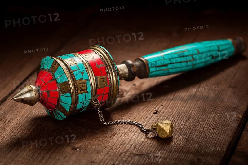 Tibetan buddhist Mani wheel or hand prayer wheel on wooden background