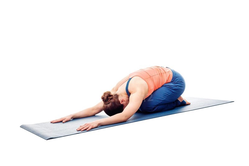 Woman doing Ashtanga Vinyasa Yoga relaxation asana Balasana, child posture, resting pose or counter asana for many asanas isolated on white background