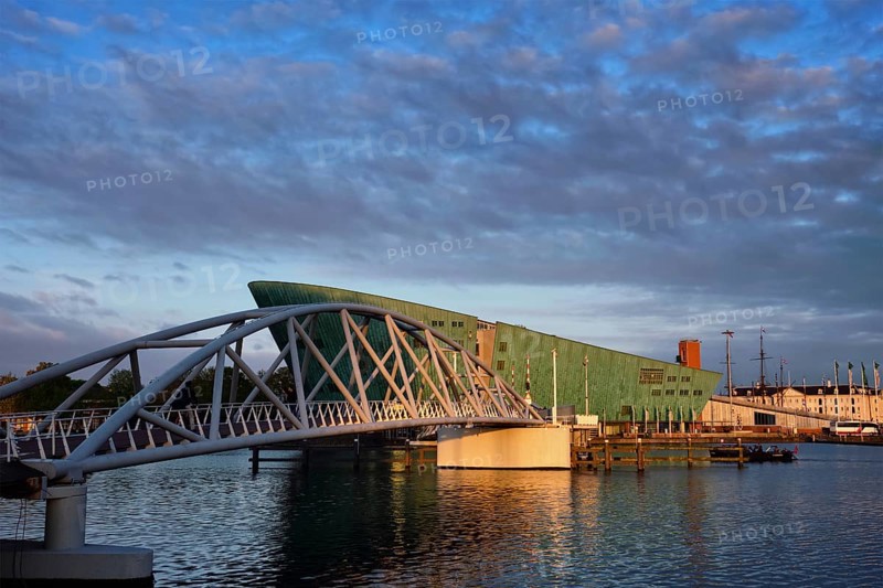 AMSTERDAM, NETHERLANDS, MAY 9, 2017: NEMO Science museum and Mr. J. van der Veldebrug bridge. It is the largest science center in Netherlands with over 500000 visitors per year