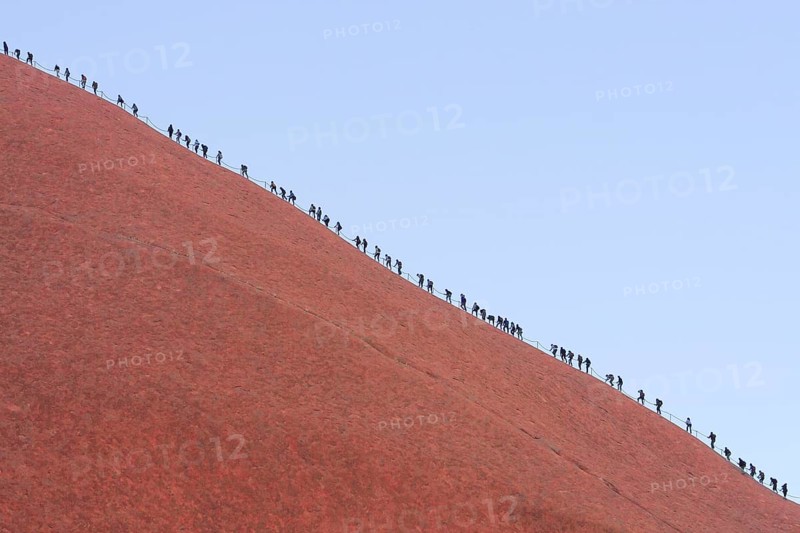 A long queue of people climbs the steep red rock face of Uluru (Ayers Rock), Australia, Oceania