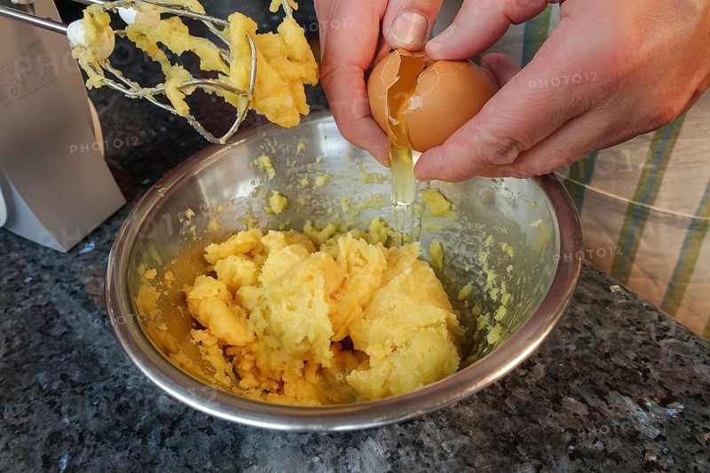 Swabian cuisine, preparing choux pastry for mini cream puffs, adding egg to raw choux pastry, whisking, whisking in pot, whisking egg, eclairs, profiteroles, piped pastry, oven baked pastry, choux pastry doughnuts, making pastry, hearty, salty, vegetarian, baking, out of the oven, typical Swabian reinterpreted, party pastry, finger food, appetisers for on the go, traditional cuisine reinterpreted, men's hands, food photography, studio, Germany, Europe