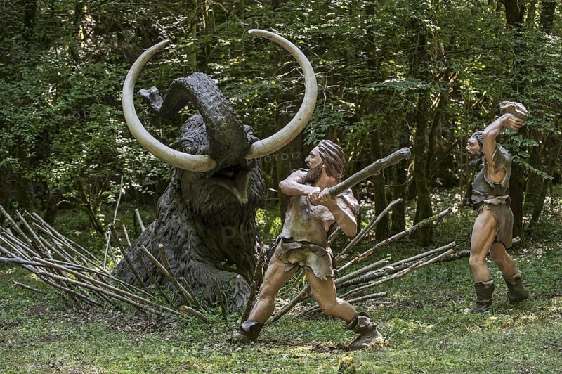 Diorama showing Neanderthal hunters killing trapped prehistoric mammoth at Prehisto Parc, theme park about prehistoric life at Tursac, Périgord, Dordogne, France, Europe