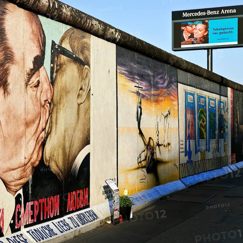 Brotherly Kiss, painting by Dmitri Vrubel on a remnant of the Berlin Wall with advertisements for tobacco, East Side Gallery, Berlin, Germany, Europe