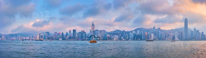 HONG KONG, CHINA, APRIL 28, 2018: Hong Kong skyline cityscape downtown skyscrapers over Victoria Harbour in the evening on sunset with junk tourist boat ferries, Hong Kong, China, Asia