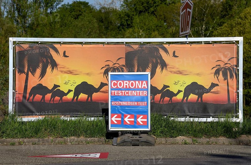 Sign Corona Testcenter in front of camels, border crossing between Gambsheim (France) and Freistett, city of Rheinau, Ortenaukreis, Baden-Württemberg, Germany, Europe