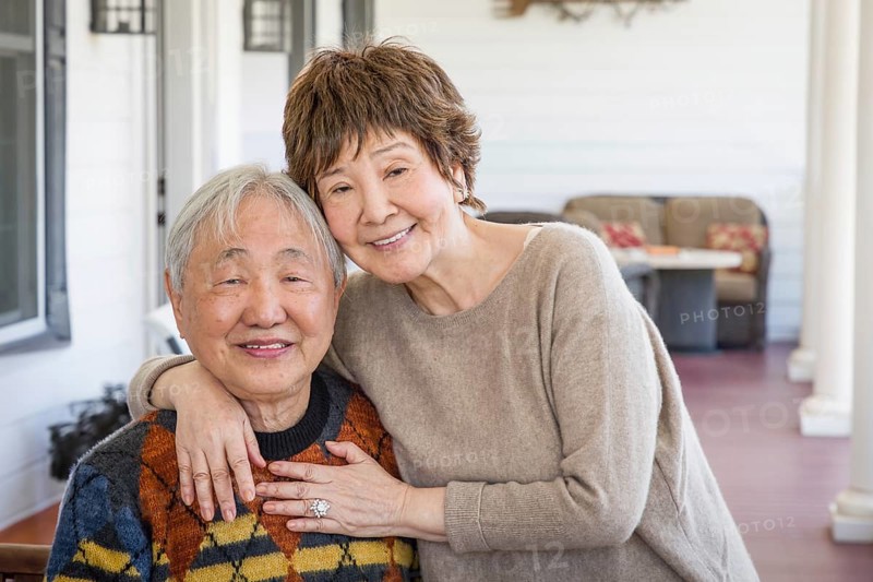 Happy senior chinese couple pose for their portrait on the porch
