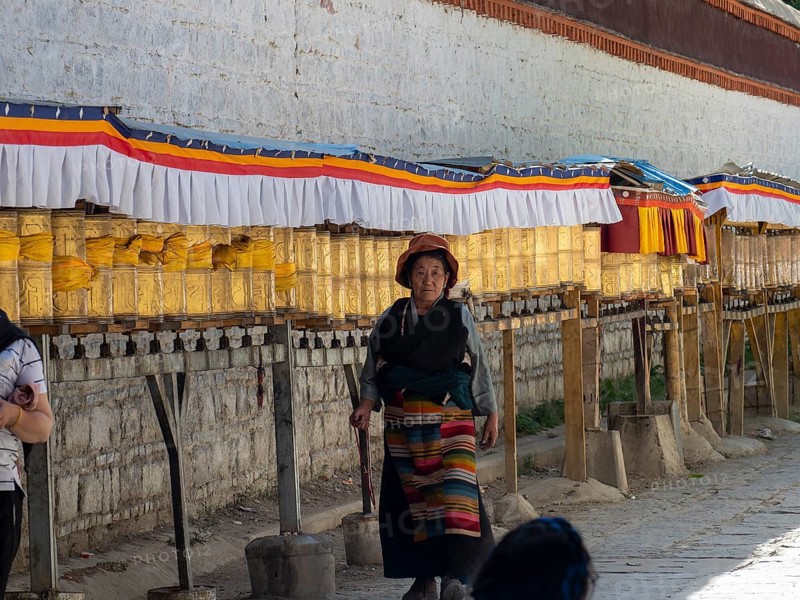 Pilgrims at golden prayer wheels, Xigaze, Tibet, China, Asia