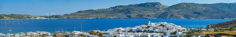 Panorama of Plaka village with traditional Greek church white painted Greek houses and ocean coast. Milos island, Greece, Europe