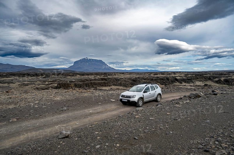 Car on a dirt road, Herðubreið Table Mountain behind, volcanic landscape, barren landscape, Vatnajökull National Park, Icelandic Highlands, Iceland, Europe