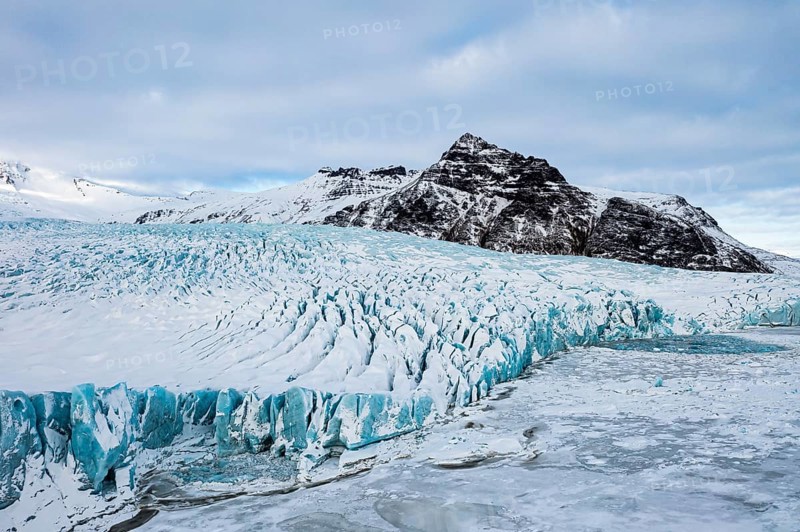 Snow-covered icebergs in the Fjallsarlon glacier lagoon, with the Öraefajökull glacier behind, drone shot, Sudurland, Iceland, Europe
