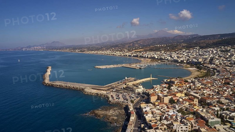 Drone shot, Venetian harbour, harbour wall, parts of the old town, mountains, lighthouse, blue sky, few grey-white clouds, Rethimnon, central Crete, island of Crete, Greece, Europe