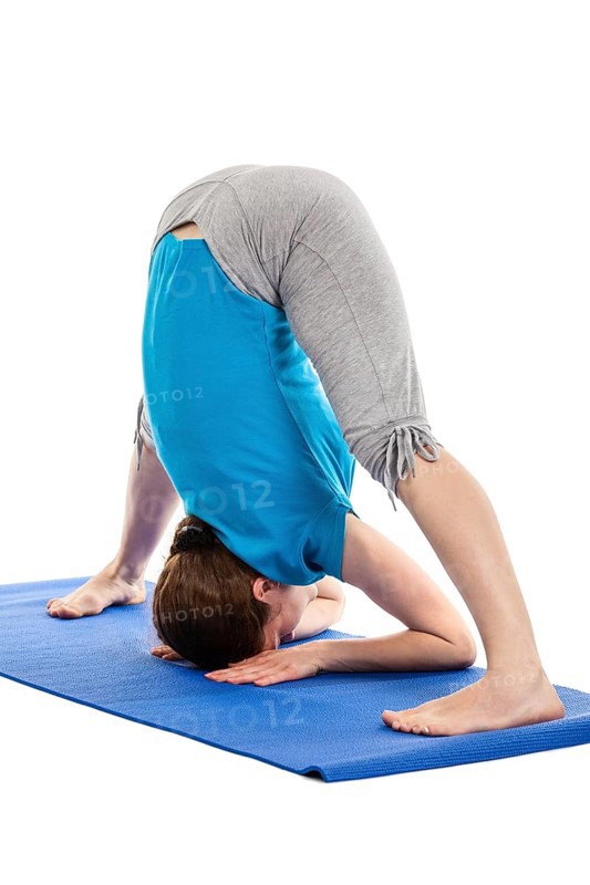 Yoga, young beautiful slender woman yoga instructor doing Wide Legged standing Forward Bend A (Prasarita Padottanasana A) asana exercise isolated on white background