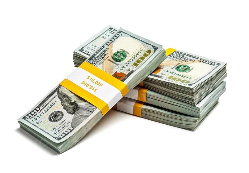 Creative business finance making money concept, stack of bundles of 100 US dollars 2013 edition banknotes bills isolated on white