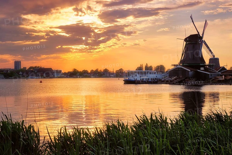 Windmills at famous tourist site Zaanse Schans in Holland on sunset with dramatic sky. Zaandam, Netherlands