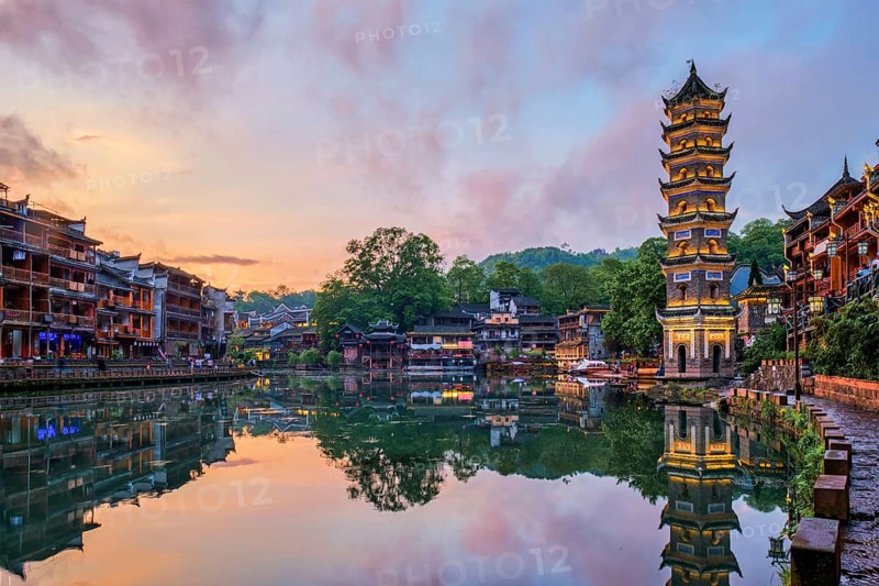 Chinese tourist attraction destination, Feng Huang Ancient Town (Phoenix Ancient Town) on Tuo Jiang River with Wanming Pagoda illuminated at night. Hunan Province, China, Asia