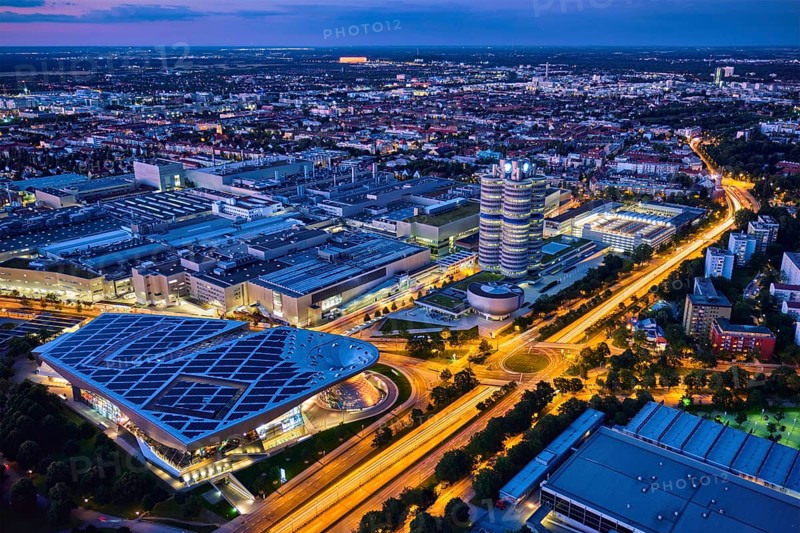 MUNICH, GERMANY, JULY 08, 2018: Aerial view of BMW Museum and BWM Welt and factory and Munich from Olympic Tower illuminated at night. BMW is a famous German luxury car automaker