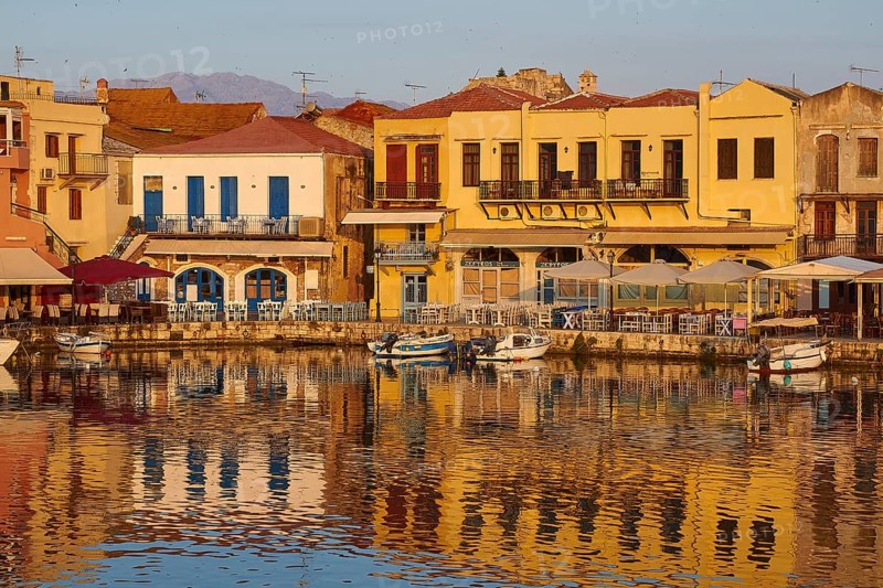Morning light, sunrise, Venetian harbour, row of houses, colourful houses, reflections in the water, blue cloudless sky, Rethimnon, Central Crete, island of Crete, Greece, Europe