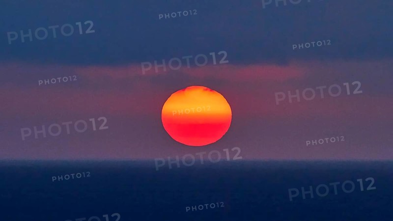 Sun as a fiery red big ball, blue-purple sky, sun just above the horizon, sunset, evening light, Rodopou peninsula, Gramvoussa peninsula, West Crete, island of Crete, Greece, Europe