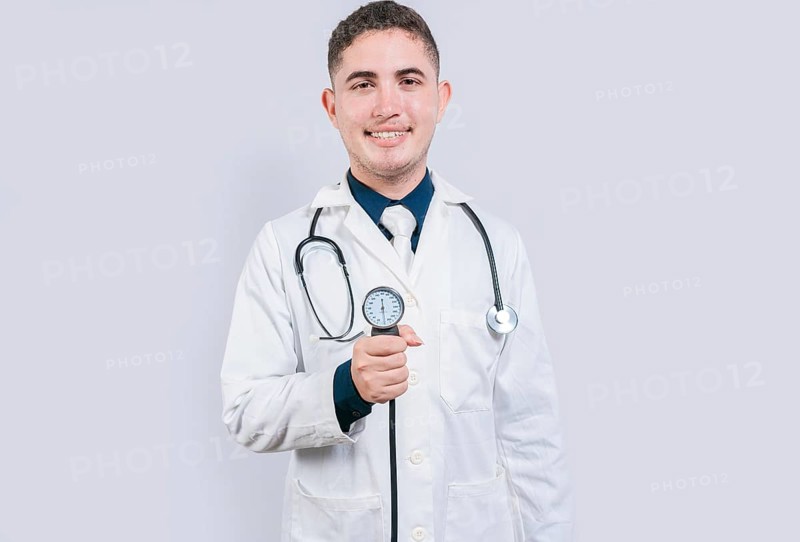 Cheerful doctor holding blood pressure monitor. Young doctor showing blood pressure monitor isolated