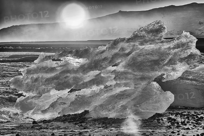 Backlit block of ice, b&w image, beach at glacier lagoon Jökulsarlon, Breiðamerkursandur, south coast, Iceland, Europe