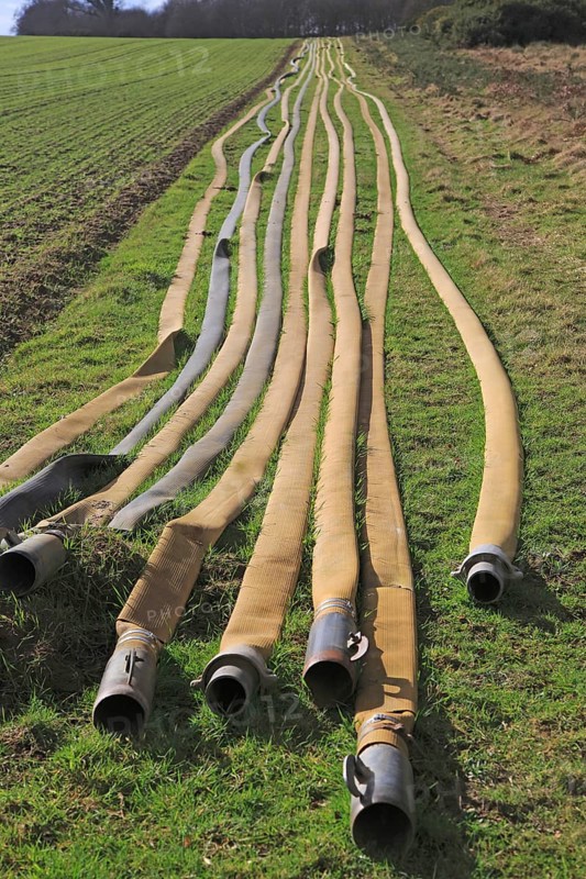 Long lines of irrigation hose pipes laid out on the ground, Shottisham, Suffolk, England, UK