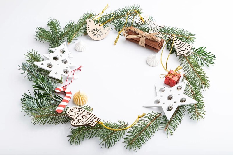 Christmas or New Year wreath composition. Decorations, stars, bells, fir and spruce branches, on white background. Side view, copy space