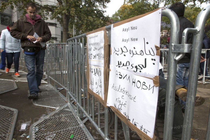 Refugees from Syria waiting to be registered at the Central Reception Centre for Asylum Seekers at the Berlin State Office for Health and Social Affairs, signs indicating waiting numbers, 09/10/2015