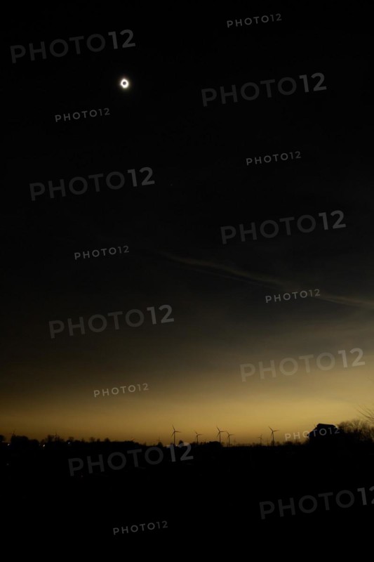 Van Wert, Ohio USA, 8 April 2024, A total solar eclipse, seen from rural northwestern Ohio. As darkness fell, the red warning lights atop wind turbines lighted up, along with a few nearby street lights