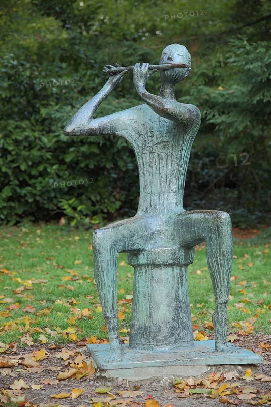 Sculpture Flute player by Walter Wadephul 1965, modern art, bronze, sitting, stool, flute, playing music, spa garden Wiesbaden, Hesse, Germany, Europe