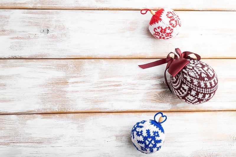 Christmas or New Year composition. Decorations, knitted balls, on a white wooden background. Top view, copy space, flat lay